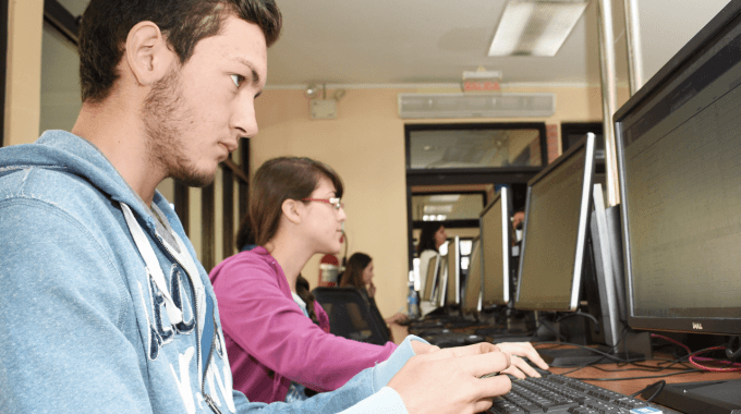 Imagen con varios estudiantes frente a la computadora.