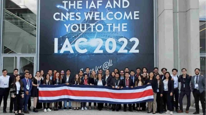 Decenas de costarricenses posan con la bandera nacional frente al rótulo del Congreso.