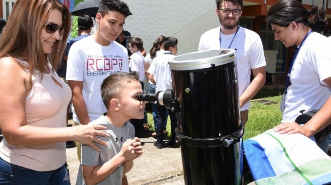 niño viendo a través de telescopio