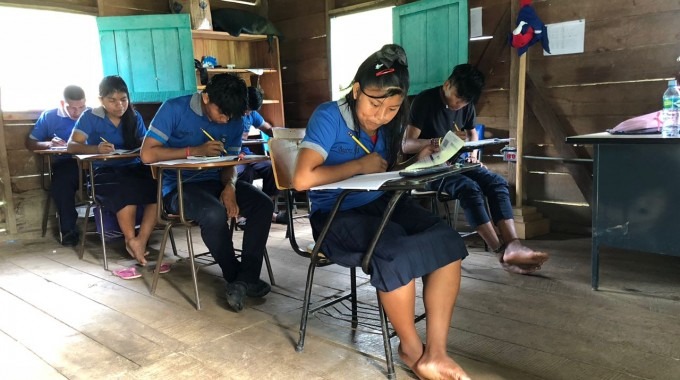 estudiantes indígenas en un escritorio haciendo examen.  