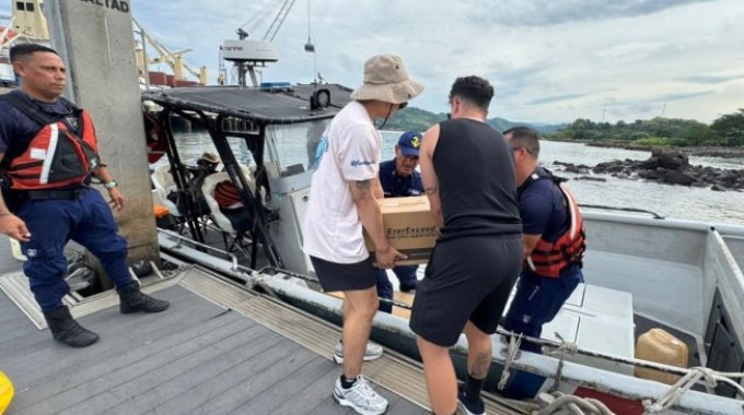 Imagen de 5 personas trabajando en Isla Caballo. Están cargando la lancha con donaciones.