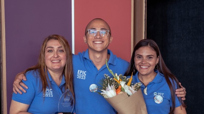 Los tres jóvenes posando con camisas de EPIC y un ramo de flores.