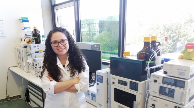 Laura Calvo, de pie, frente a unas máquinas en el laboratorio.