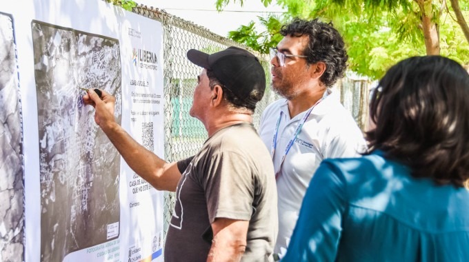 Un adulto mayor enseña detalles de la ciudad en una fotografía aérea