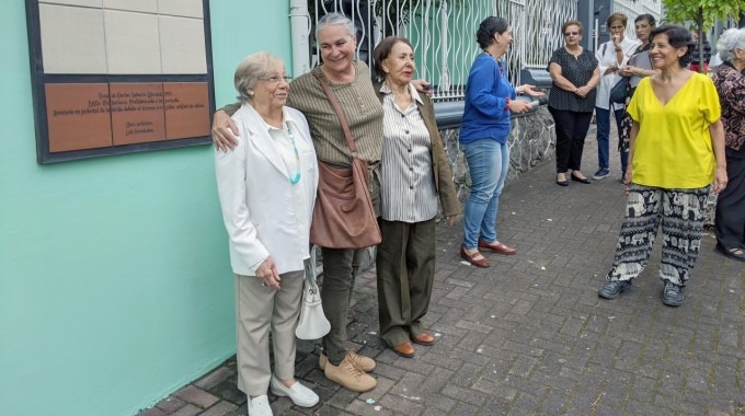 Las tres artistas sonríen, junto a la obra. 