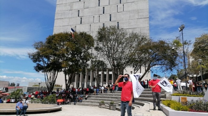 Personas manifestándose frente al edificio de la Asamblea Legislativa.