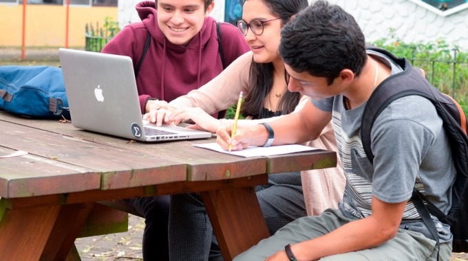 estudiantes frente a computadora en banca del pretil