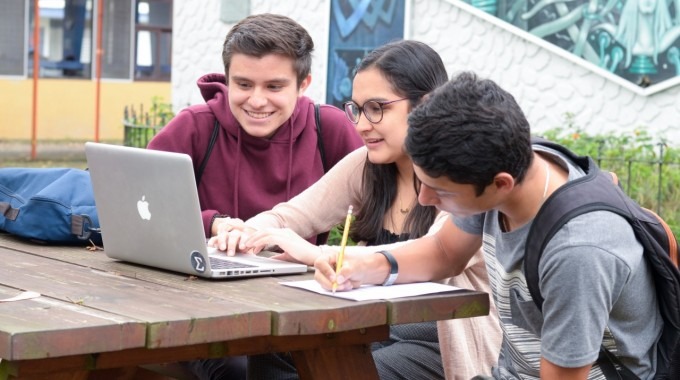 imagen de tres estudiantes  frente a una computadora