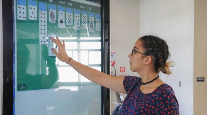 Mujer jugando cartas en la pantalla  de los kioscos informativos del kioscos informativos.