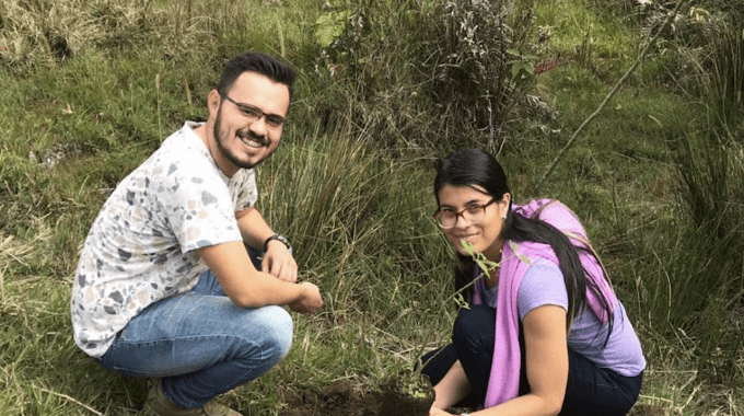 imagen de un hombre y una mujer sembrando  un árbol