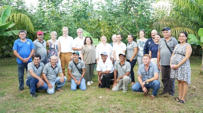 Un grupo de personas posan frente a la plantación.