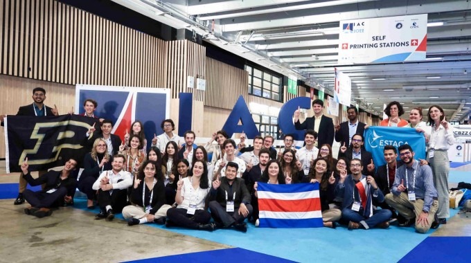 Integrantes de Polaris frente al rótulo de IAC 2022, con la bandera de Costa Rica.