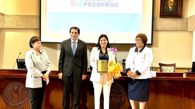 Imagen de cuatro personas posando para la foto. Momento de la entrega del reconocimiento a la Rectora del TEC.