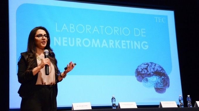 Mujer exponiendo el tema de neuromarketing a un grupo de empresarios.