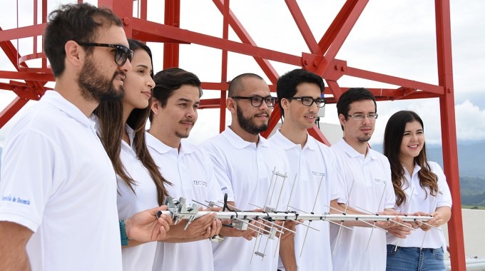 Los estudiantes posan frente a una antena de comunicaciones.