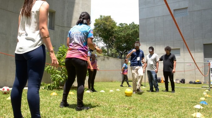 Varias personas juegan fútbol con los ojos vendados.