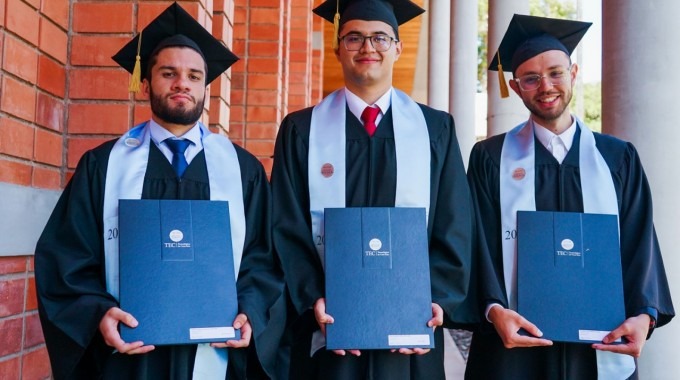 Tres jóvenes con sus títulos. 