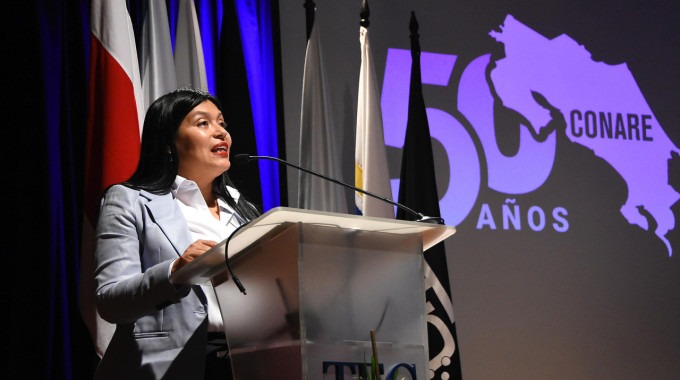 María Estrada con el logo de CONARE atrás.