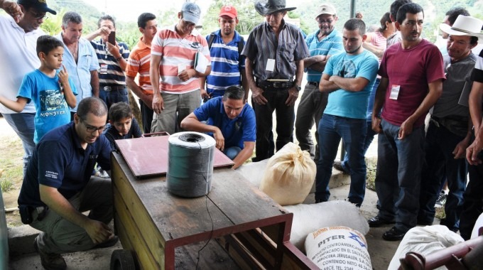 Productores observando a dos especialistas con camisas del TEC.