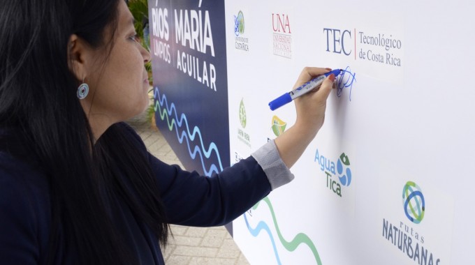 La integrante del Consejo Institucional, María Estrada, firma la manta representativa del Pacto. 