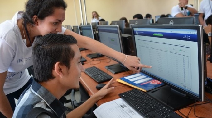 estudiantes frente a computadora señalando monitor