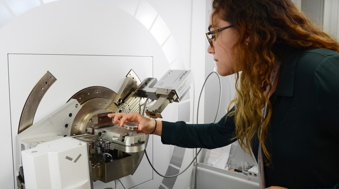 Una joven introduce cristales en el difractómetro de rayos X.