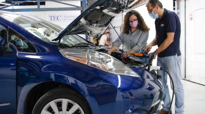 La estudiante y el profesor revisando un vehículo eléctrico.