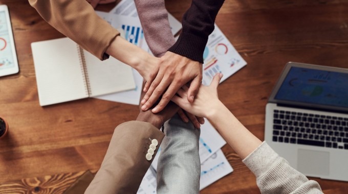 Manos juntas de personas trabajando en equipo. 