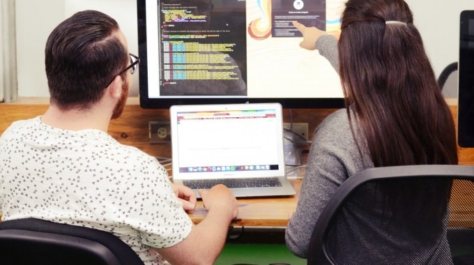 jóvenes señalando una computadora 