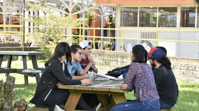Imagen de varios estudiantes sentados  en una mesita del TEC.