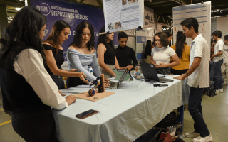 Imagen de varias estudiantes con sus respectivos proyectos en la feria de la Escuela de Ciencia e Ingeniería de los materiales