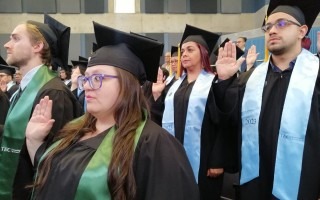 imagen de varios estudiantes levantando la mano en la juramentación.