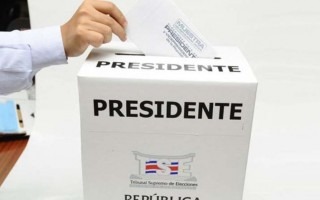 Una mano ingresando un voto en la urna. 