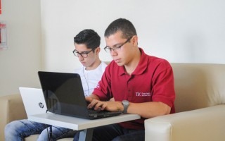 Imagen de dos estudiantes frente a la computadora