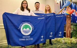 tres personas con banderas azules