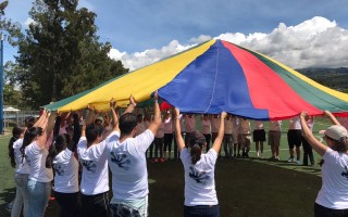 ALUMNOS EN CAMPO CON MANTA DE COLORES