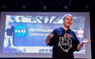 Bruce Callow frente a una proyección de una foto de un laboratorio de NASA.