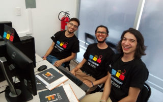 jovenes_programadores_sonriendo_sentados_frente_a_computadora_durante_competencia_