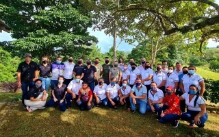 Miembros de la comunidad y de la gira posando en un área verde.