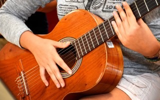 manos sobre guitarra