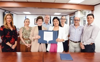 Imagen con ocho personas posando para la fotografía. Muestran el documento firmado.