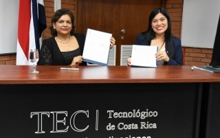 Imagen de dos mujeres mostrando un documento que firmaron.