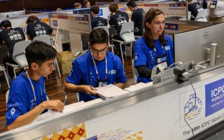 Imagen de tres estudiantes en la competencia.