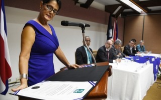 mujer leyendo certificado de acreditación en conare