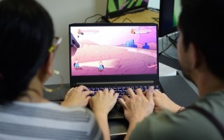 dos jóvenes frente a computadora con videojuegos