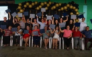 las personas graduadas muestran su título.