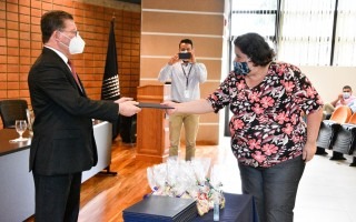 La estudiante recibe el título.