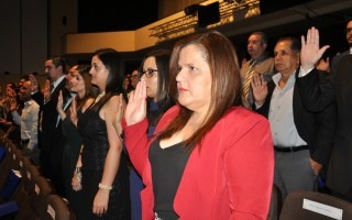 Imagen de varias personas levantando la mano derecha durante la juramentación.