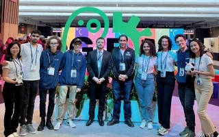 Los jóvenes posan frente al logo de iGEM.