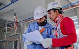 dos hombres en construcción sosteniendo plano